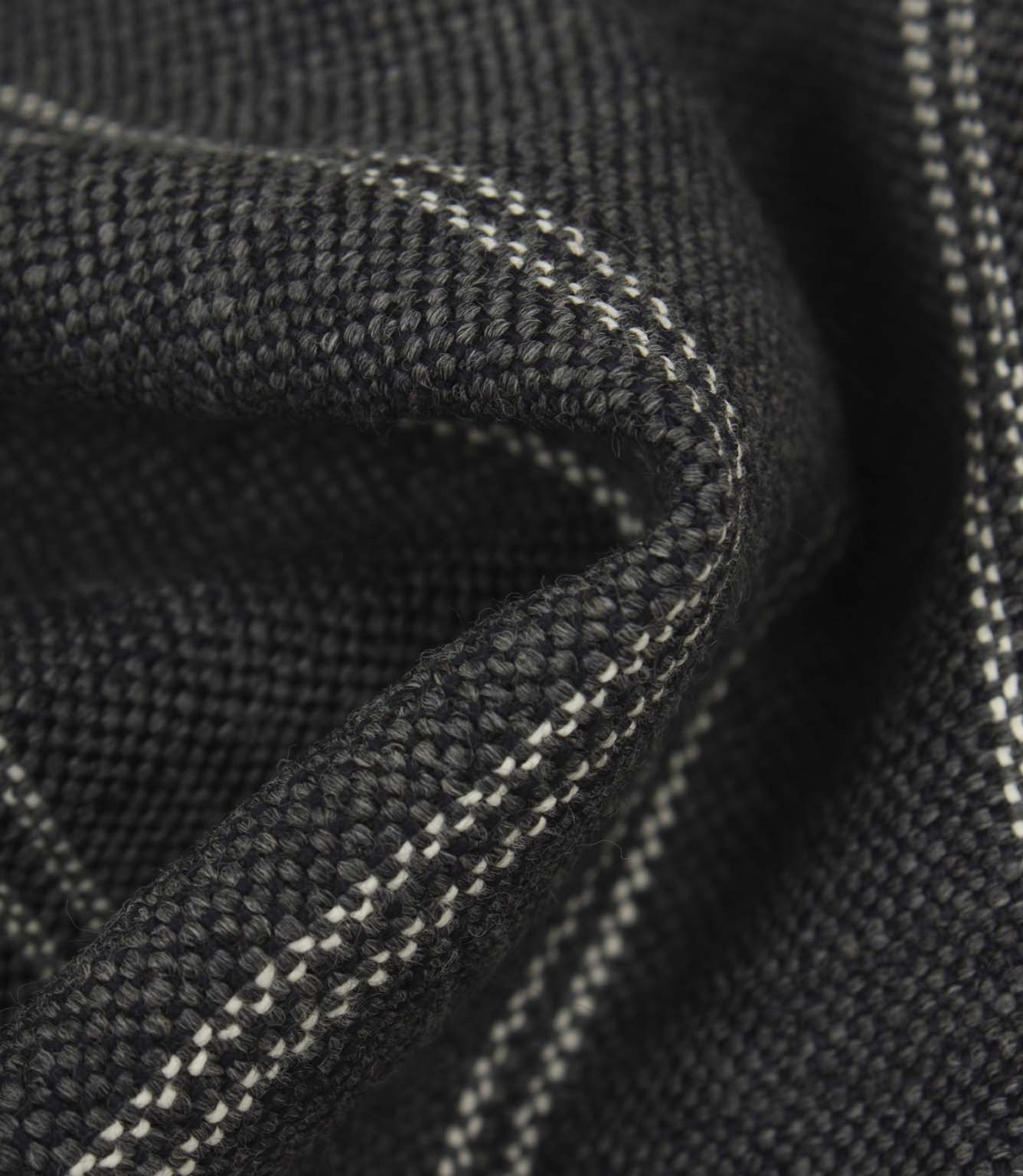 Macro detail of ink blue upholstery fabric showing the textured weave and subtle white stitched stripes.
