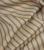Draped striped furnishing fabric with soft beige tones and fine blue vertical stripes in a classic country style.