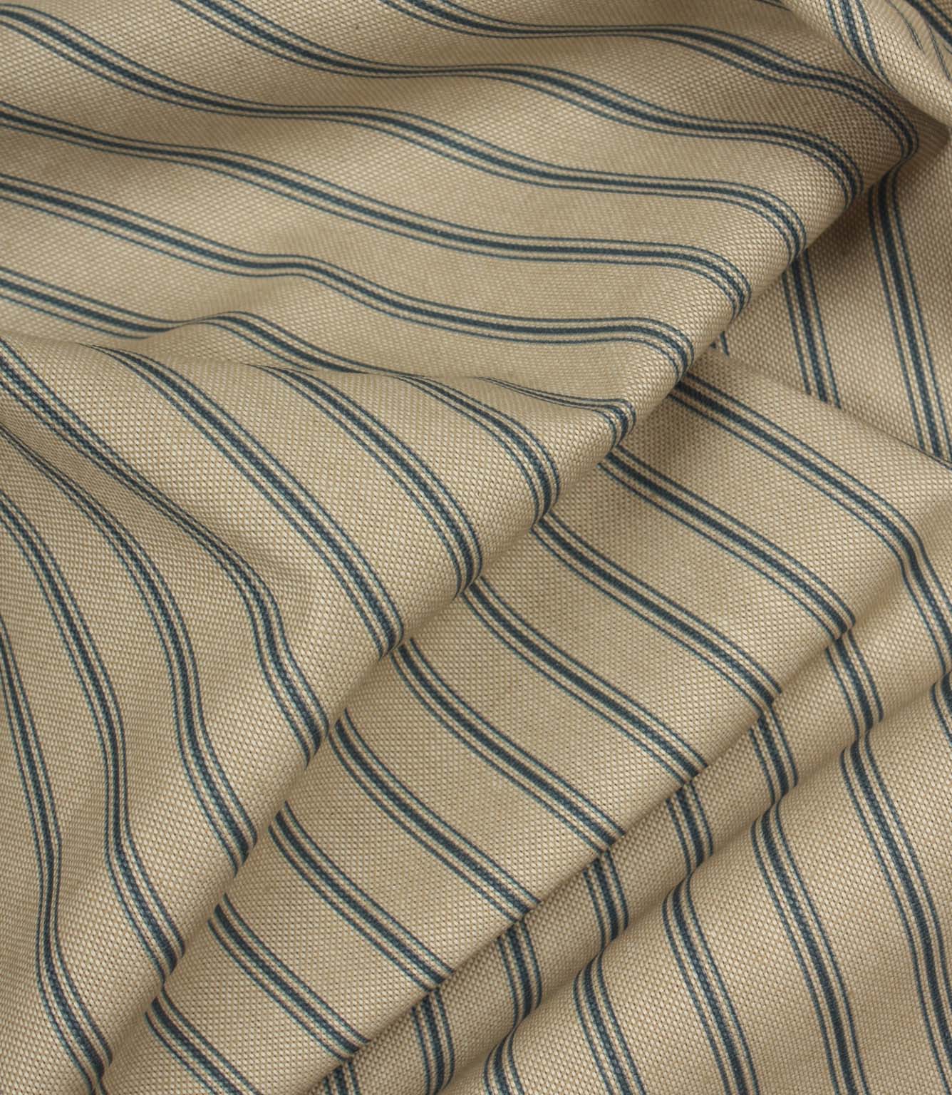 Draped striped furnishing fabric with soft beige tones and fine blue vertical stripes in a classic country style.