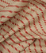 Draped neutral fabric with fine red vertical stripes in a timeless country-inspired design.