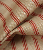 Detailed close-up of beige woven stripe fabric featuring textured weave and narrow red ticking stripes.