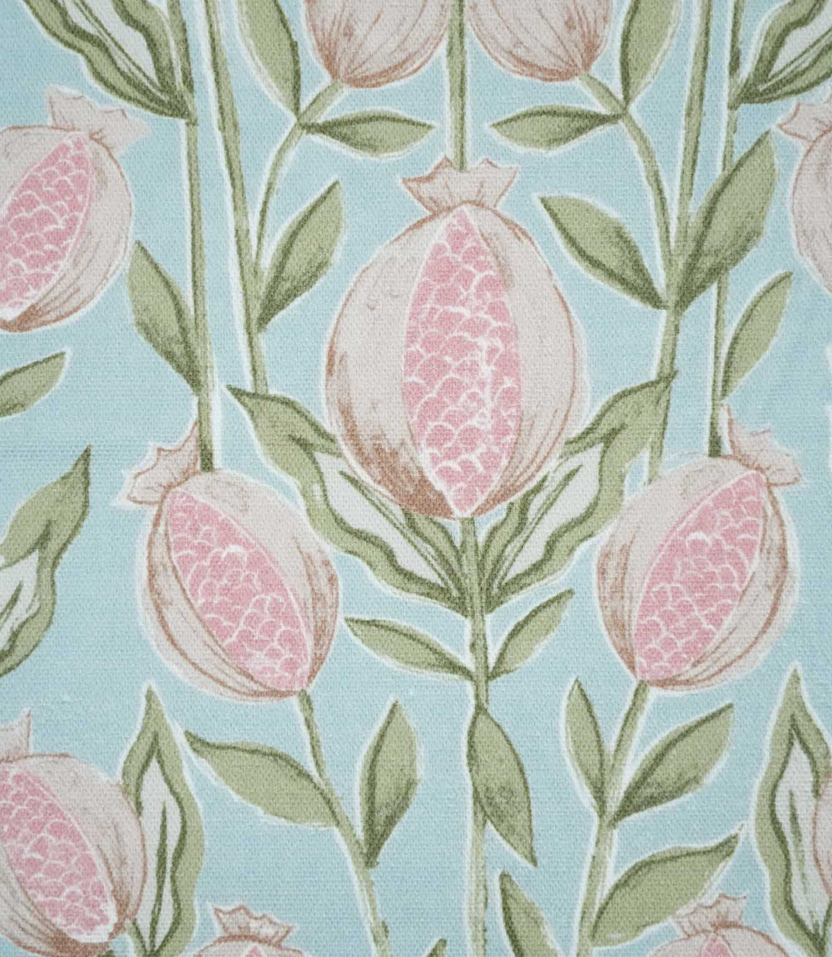 Close-up of Rithani Robin's Egg fabric showing detailed pink pomegranate seeds within cream fruit, surrounded by sage green leaves and stems against a pale blue background.