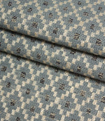Folded Rossini Denim fabric showcasing the detailed woven pattern and rich textural finish.