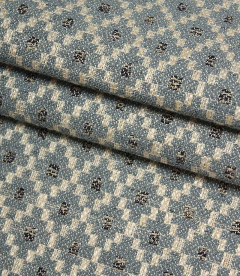 Folded Rossini Denim fabric showcasing the detailed woven pattern and rich textural finish.