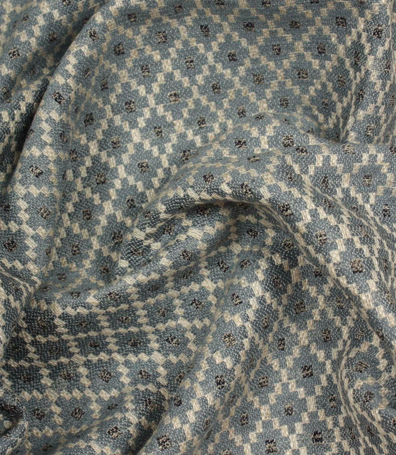 Draped Rossini Denim fabric displaying the geometric motif and soft, structured handle.