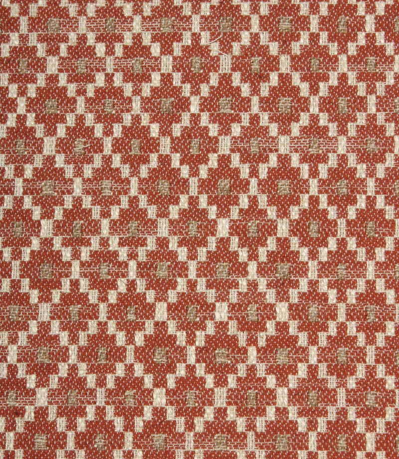 Close-up of textured upholstery fabric showcasing the intricate rust red geometric weave with cream detailing and subtle taupe highlights.