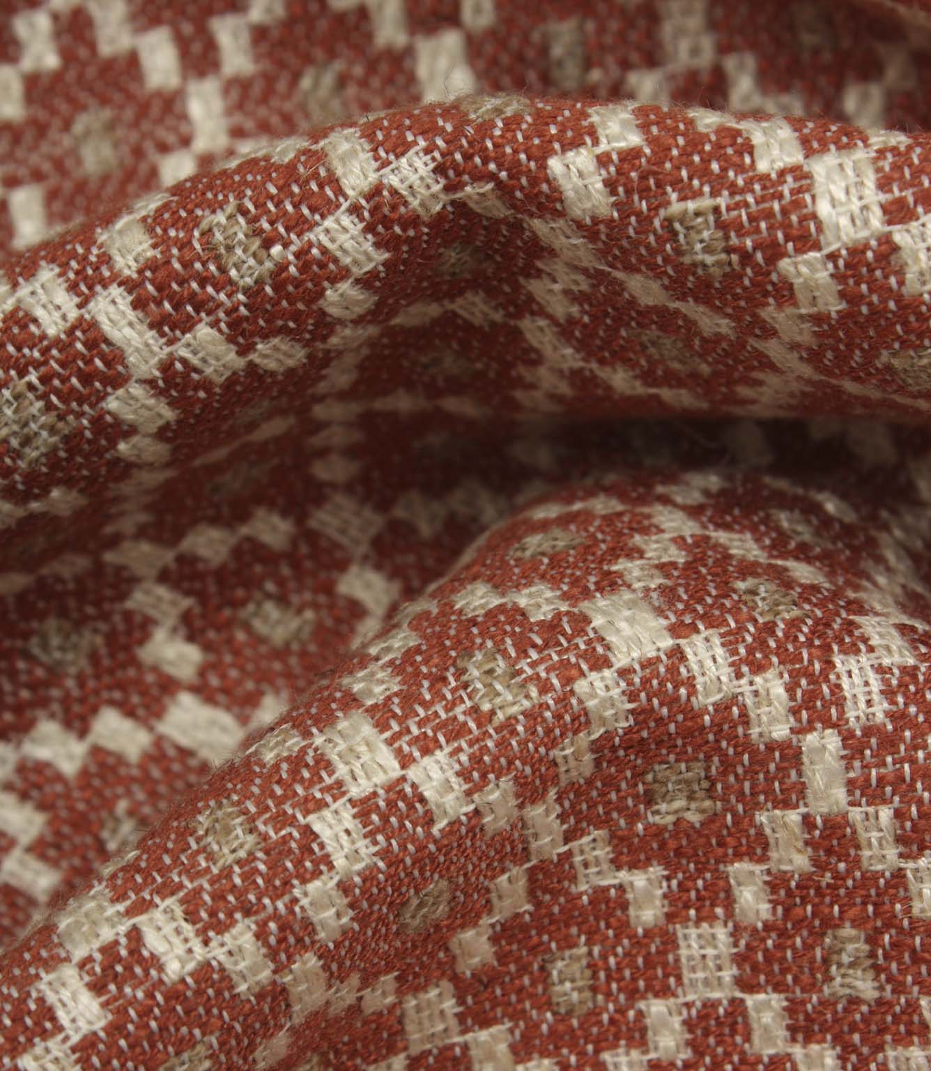 Macro close-up of woven fabric highlighting the textured surface, detailed geometric weave, and warm earthy colour palette.
