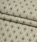Folded Rossini Mineral fabric showcasing the intricate woven pattern and upholstery-weight texture.