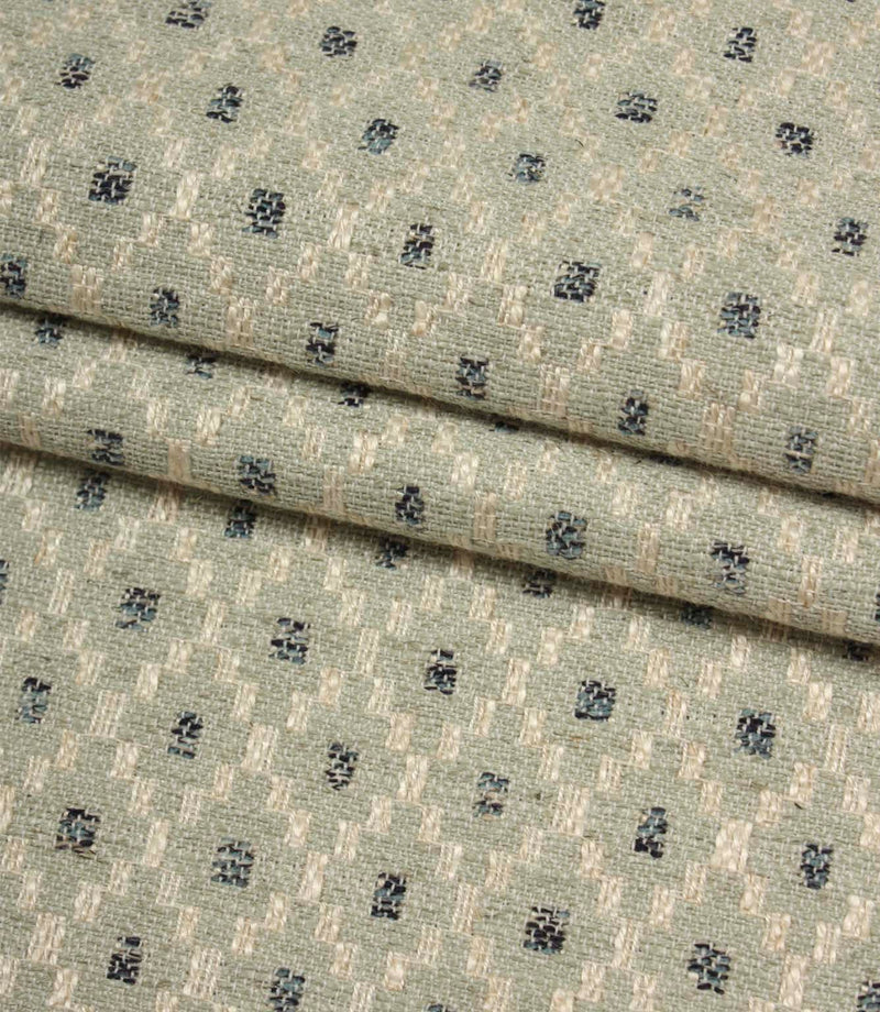 Folded Rossini Mineral fabric showcasing the intricate woven pattern and upholstery-weight texture.