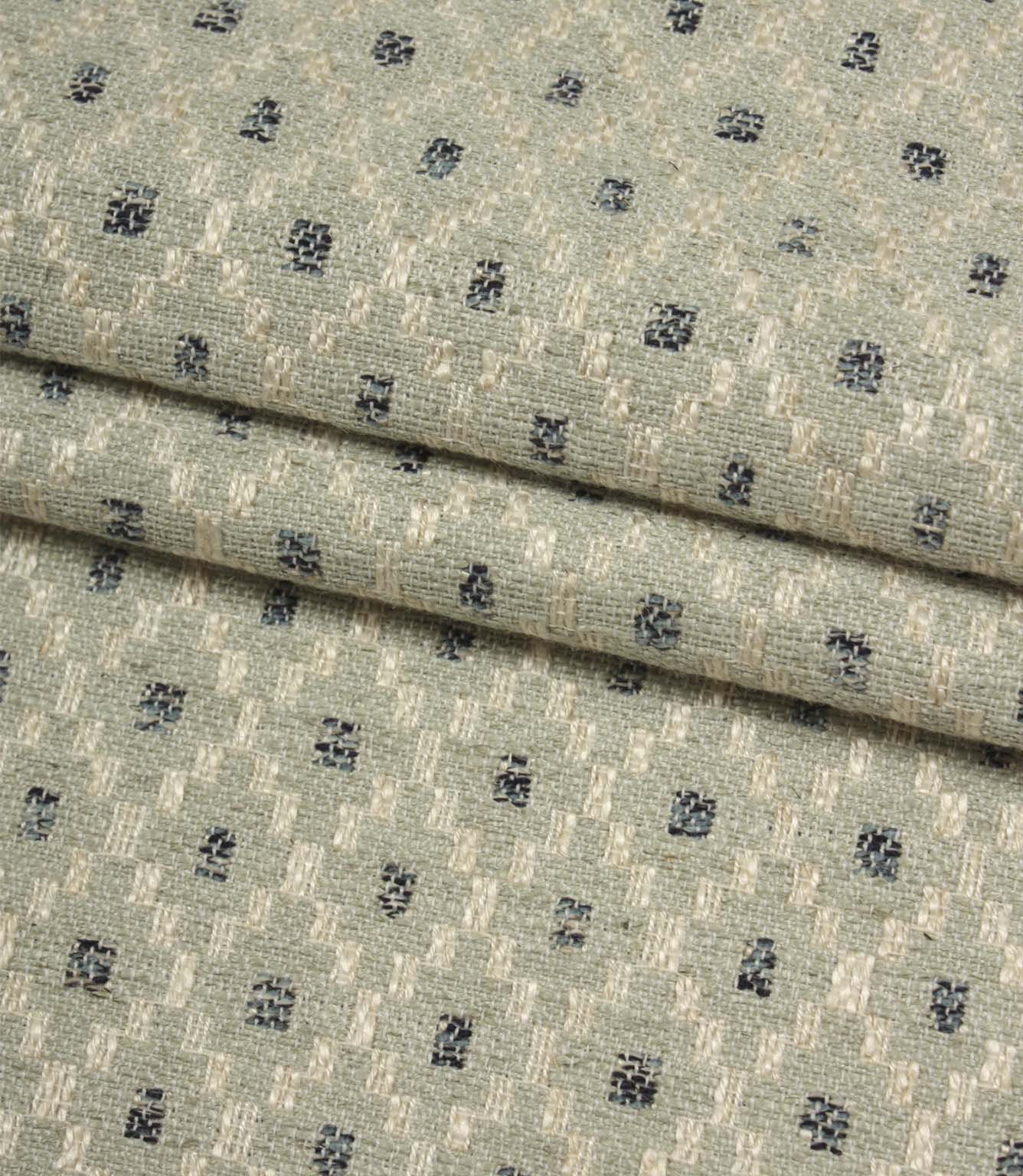 Folded Rossini Mineral fabric showcasing the intricate woven pattern and upholstery-weight texture.