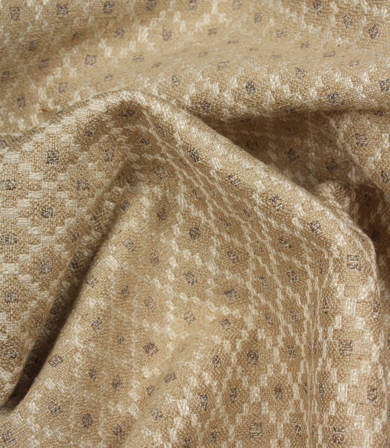 Draped Rossini Natural fabric displaying the repeating geometric motif and soft, elegant fabric movement.