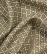 Draped geometric upholstery fabric with a soft woven handle and an intricate small-scale lattice-inspired pattern in muted earthy shades.