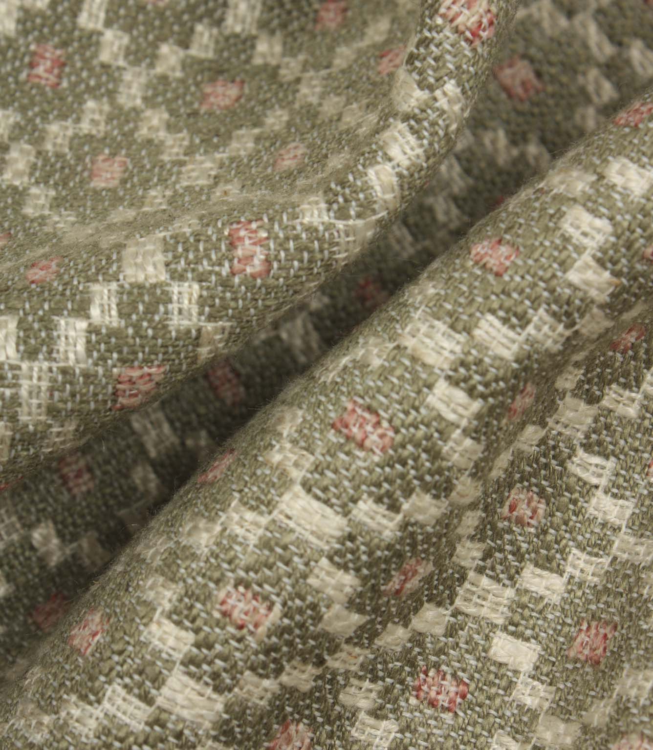 Macro close-up of woven fabric highlighting the textured surface, detailed geometric weave, and subtle sage green and blush pink colour palette.