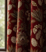 Red curtain with leaf pattern in front of a window