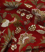 Draped red jacquard fabric with decorative jungle-inspired animal and floral pattern.