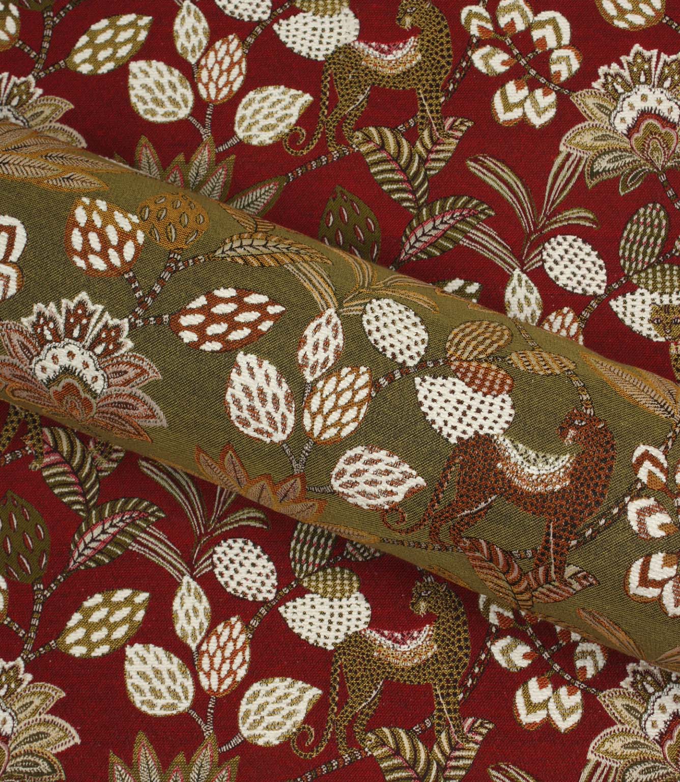 Rolled olive green leopard print fabric displayed against coordinating red botanical fabric backdrop.