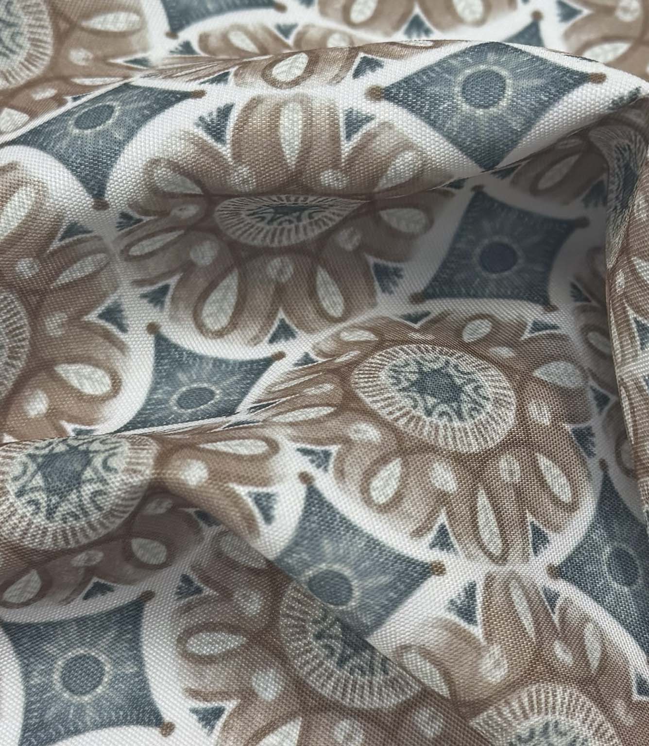 Draped Sand Rosette outdoor fabric showing a vintage-inspired floral and geometric pattern in muted teal, taupe, ivory, and grey shades.