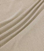Shoreham Gull striped fabric arranged in soft diagonal folds, showcasing its delicate grey and cream ticking stripe pattern, textured woven surface and natural drape.