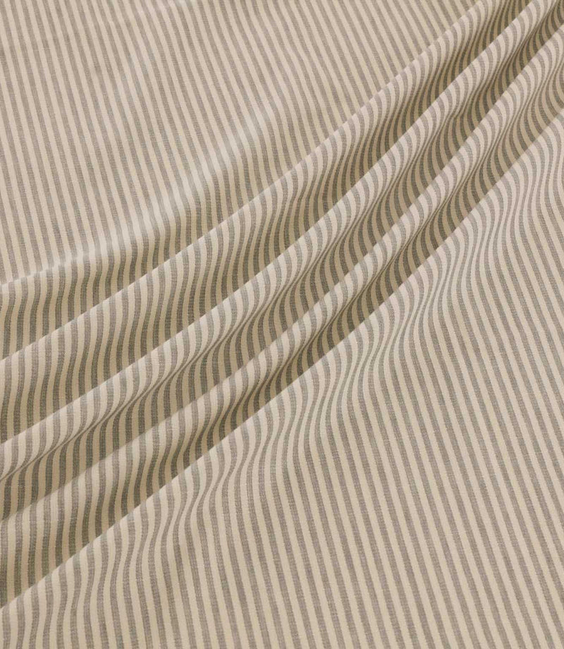 Shoreham Gull striped fabric arranged in soft diagonal folds, showcasing its delicate grey and cream ticking stripe pattern, textured woven surface and natural drape.