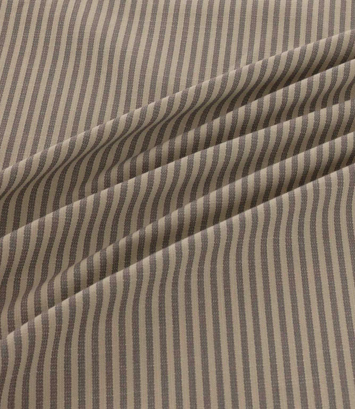 Shoreham Rockport striped fabric arranged in soft diagonal folds, showcasing its alternating taupe grey and natural beige ticking stripes, textured woven finish and gentle drape.
