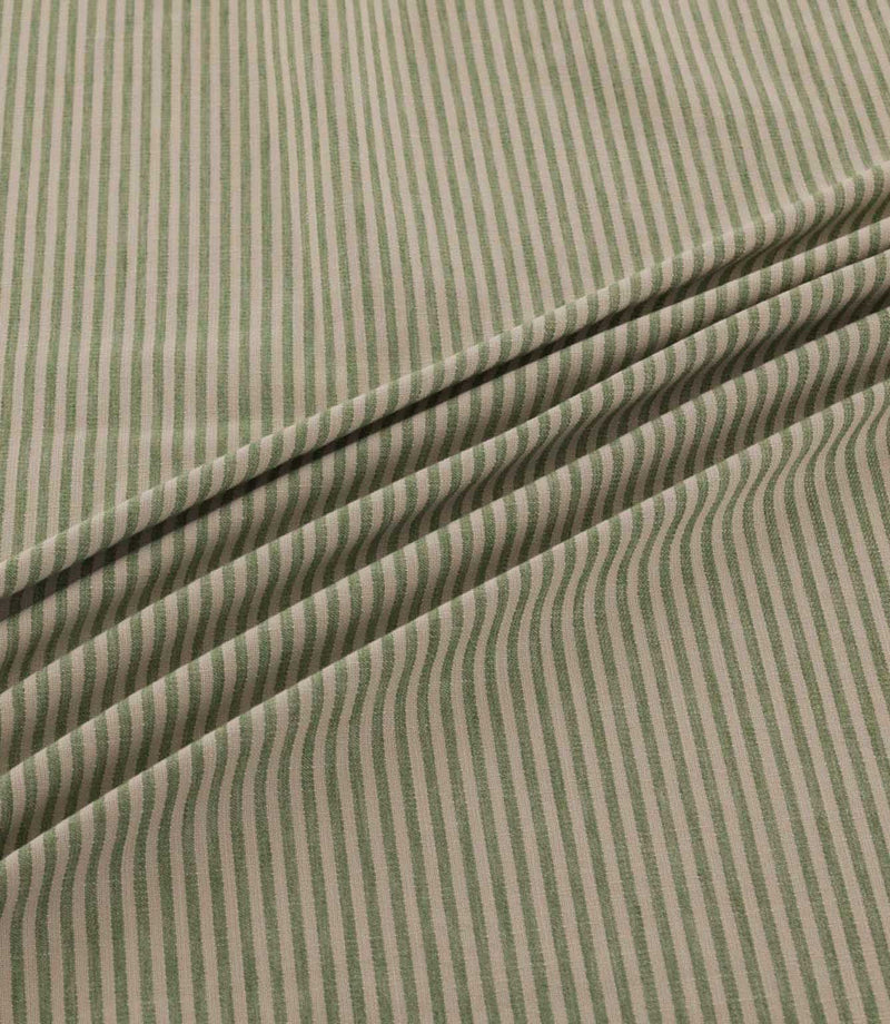 Shoreham Spring fabric arranged in soft, diagonal folds, showcasing its delicate sage green and natural beige vertical stripes, textured woven surface and gentle drape.