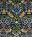 Decorative William Morris velvet fabric pattern with birds, flowers, and strawberries on a blue background