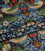 Patterned velvet William Morris fabric with birds, flowers, and strawberries on a blue background