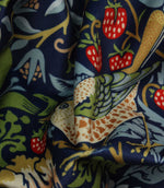 Close-up of colorful William Morris velvet fabric with strawberries and leaves pattern