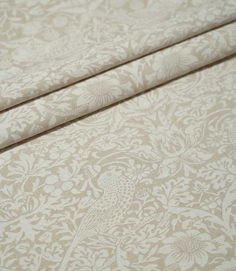Beige and off-white Strawberry Thief Linen Look fabric arranged in soft folds, showing the repeating William Morris bird, strawberry and floral pattern.