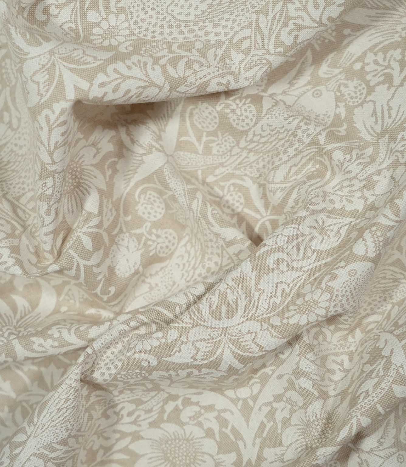 Draped Strawberry Thief Linen Look William Morris fabric in beige and off-white, showing birds amongst strawberries, flowers and dense Arts & Crafts foliage.