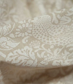 Close-up of draped Strawberry Thief Linen Look fabric in beige and off-white, highlighting the linen-look weave and detailed William Morris bird and botanical motifs.