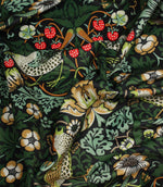 Draped Arts and Crafts style fabric featuring birds, foliage and floral motifs on a dark background.