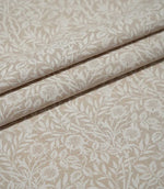 Sweet Briar Linen Look fabric arranged in neat folds, showing the cream floral and leafy design against a warm beige ground.