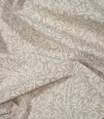 Draped Sweet Briar Linen Look fabric in cream and beige, showing the flowing floral pattern and natural texture of the woven surface.