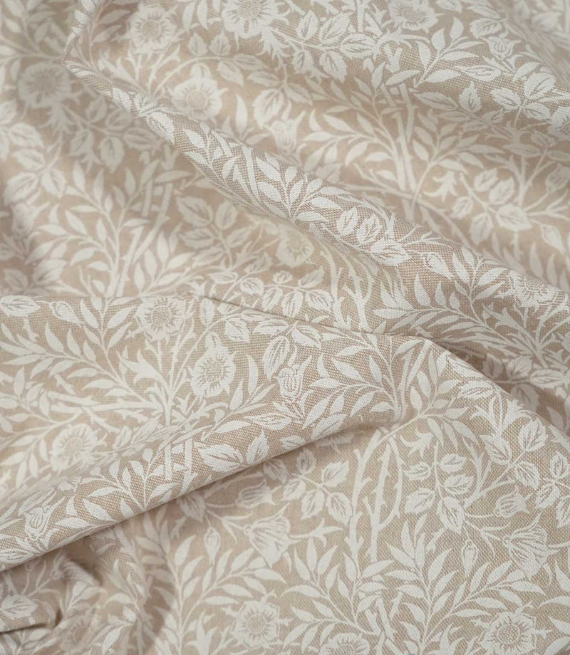 Draped Sweet Briar Linen Look fabric in cream and beige, showing the flowing floral pattern and natural texture of the woven surface.