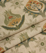 Folded fabric with repeating Arts and Crafts inspired floral pattern in muted green, ochre and blue tones.