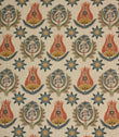 Linen-look fabric with repeating Arts and Crafts inspired floral motifs in terracotta, ochre and deep blue tones on a natural background.