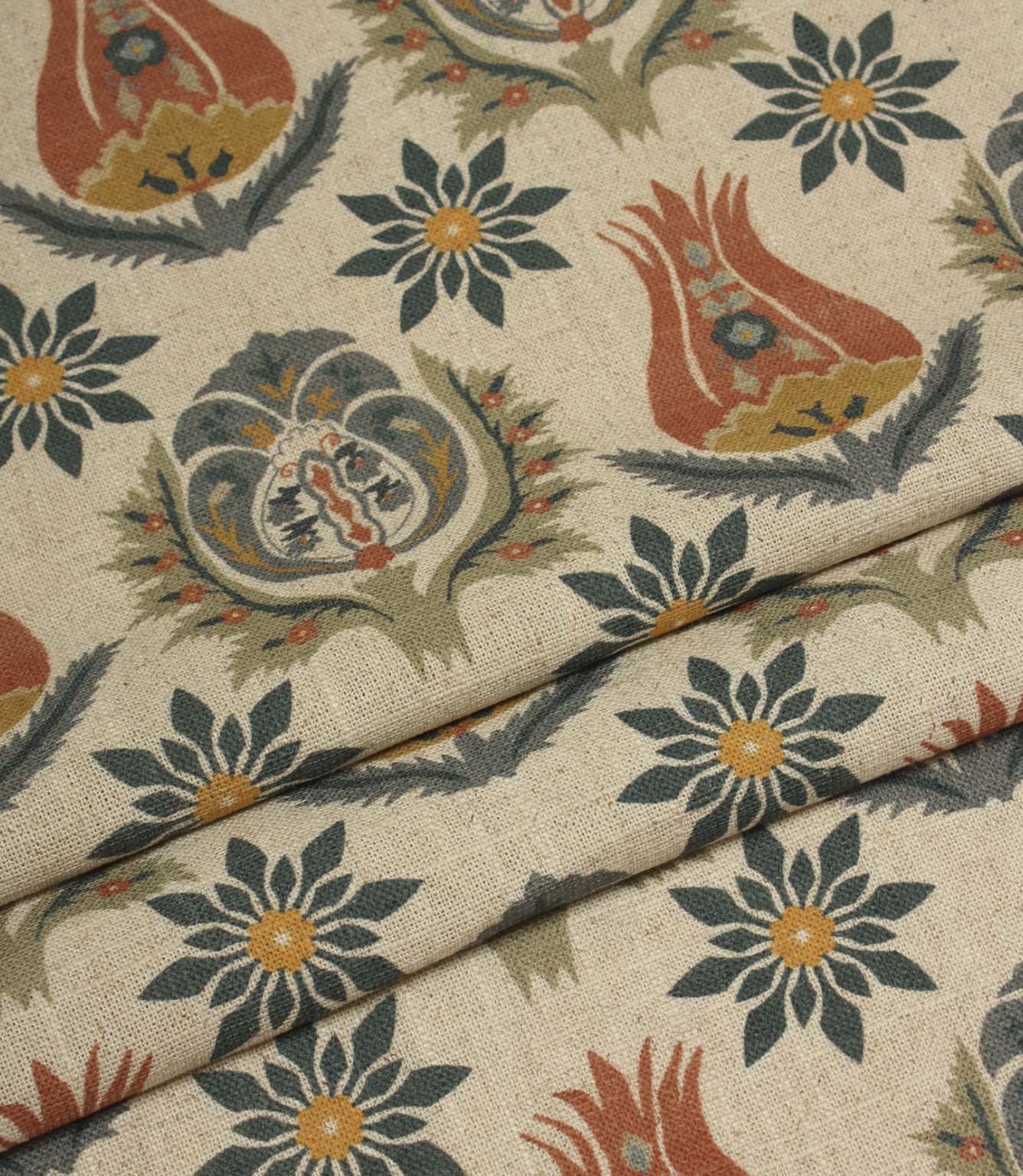 Folded natural fabric with repeating floral and botanical print in terracotta, navy and soft olive tones.
