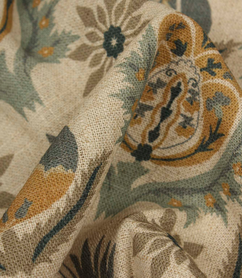Detailed close-up of textured woven fabric highlighting ornamental floral design in muted blue and ochre tones.