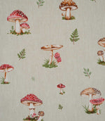 Close-up of Toadstool Meadow Multi fabric showing detailed red toadstools with white spots, brown woodland mushrooms and scattered green foliage on a textured natural beige background.