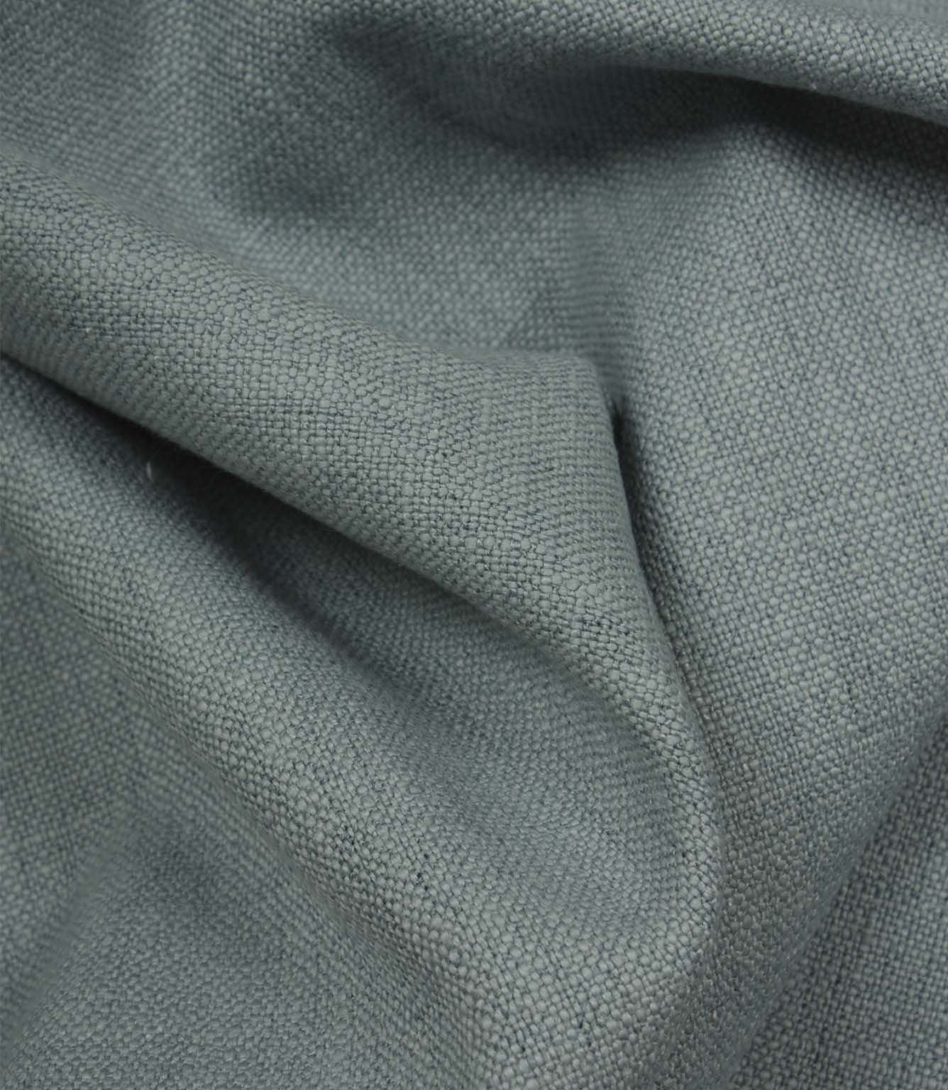 Trento woven fabric in sky draped in soft folds, illustrating its relaxed texture and suitability for curtains, blinds and cushions.