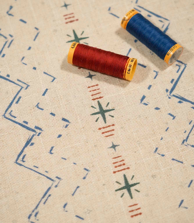 Twilight Mill Blue Chestnut fabric displayed with coordinating blue and chestnut sewing thread, highlighting the contemporary geometric print.