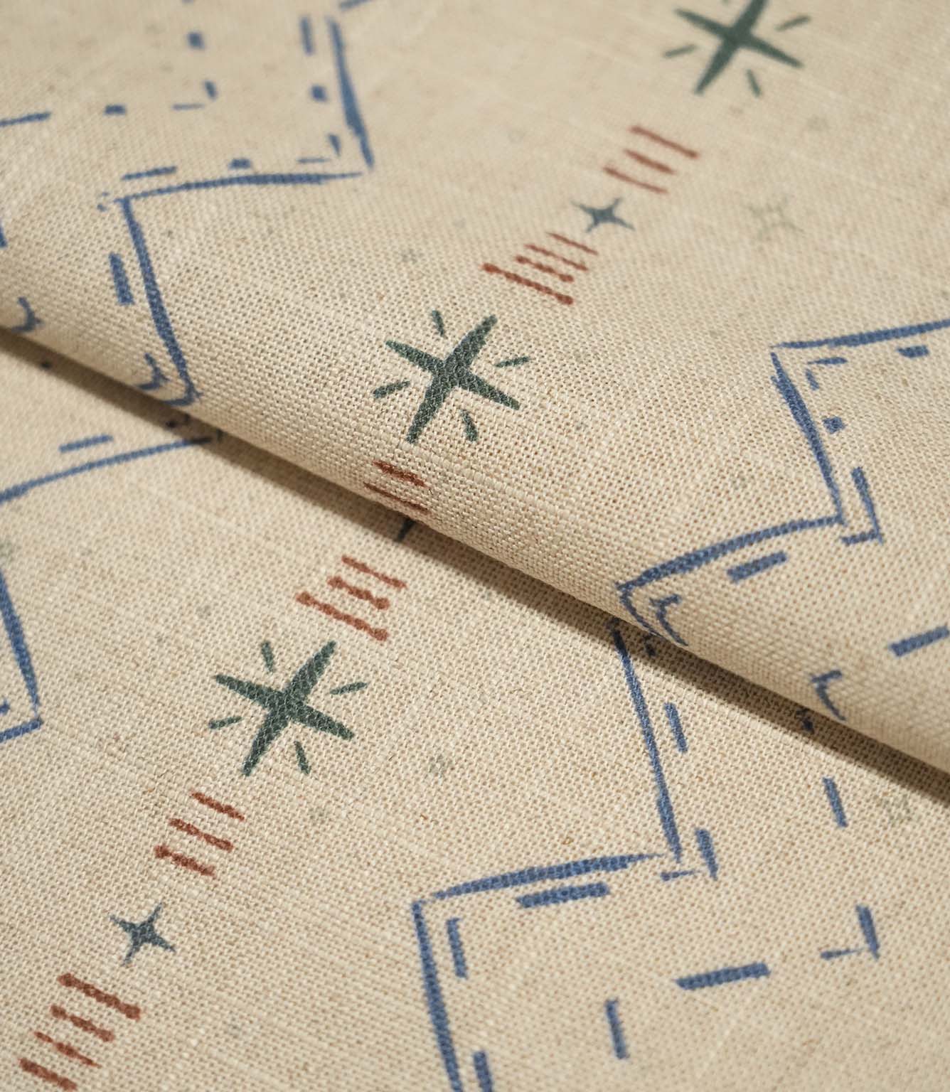 Folded Twilight Mill Blue Chestnut fabric showcasing the textured woven finish and small-scale geometric pattern.