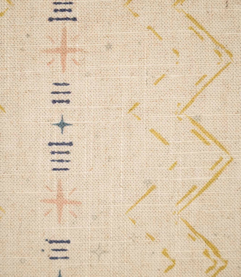 Close-up of Twilight Mill Gold fabric showing the hand-drawn geometric motif with stitched zigzags and decorative star details.
