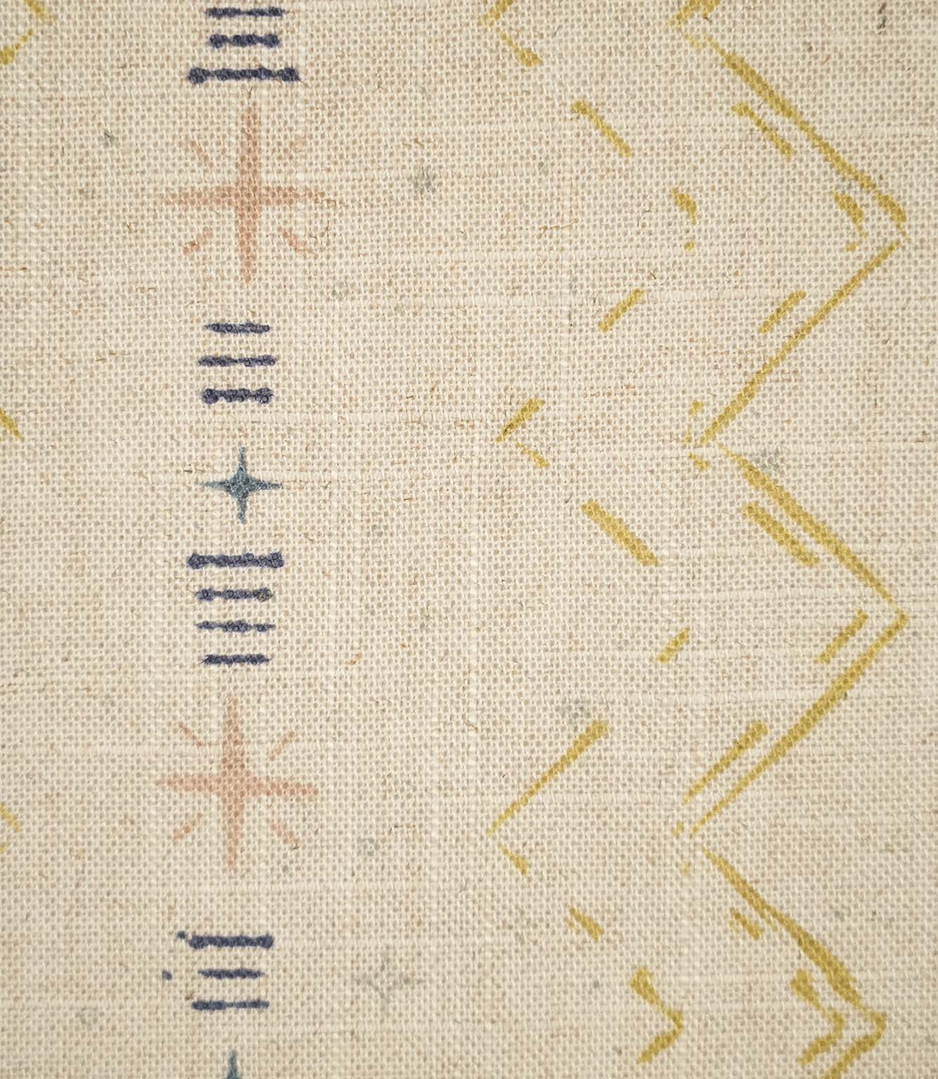 Close-up of Twilight Mill Gold fabric showing the hand-drawn geometric motif with stitched zigzags and decorative star details.