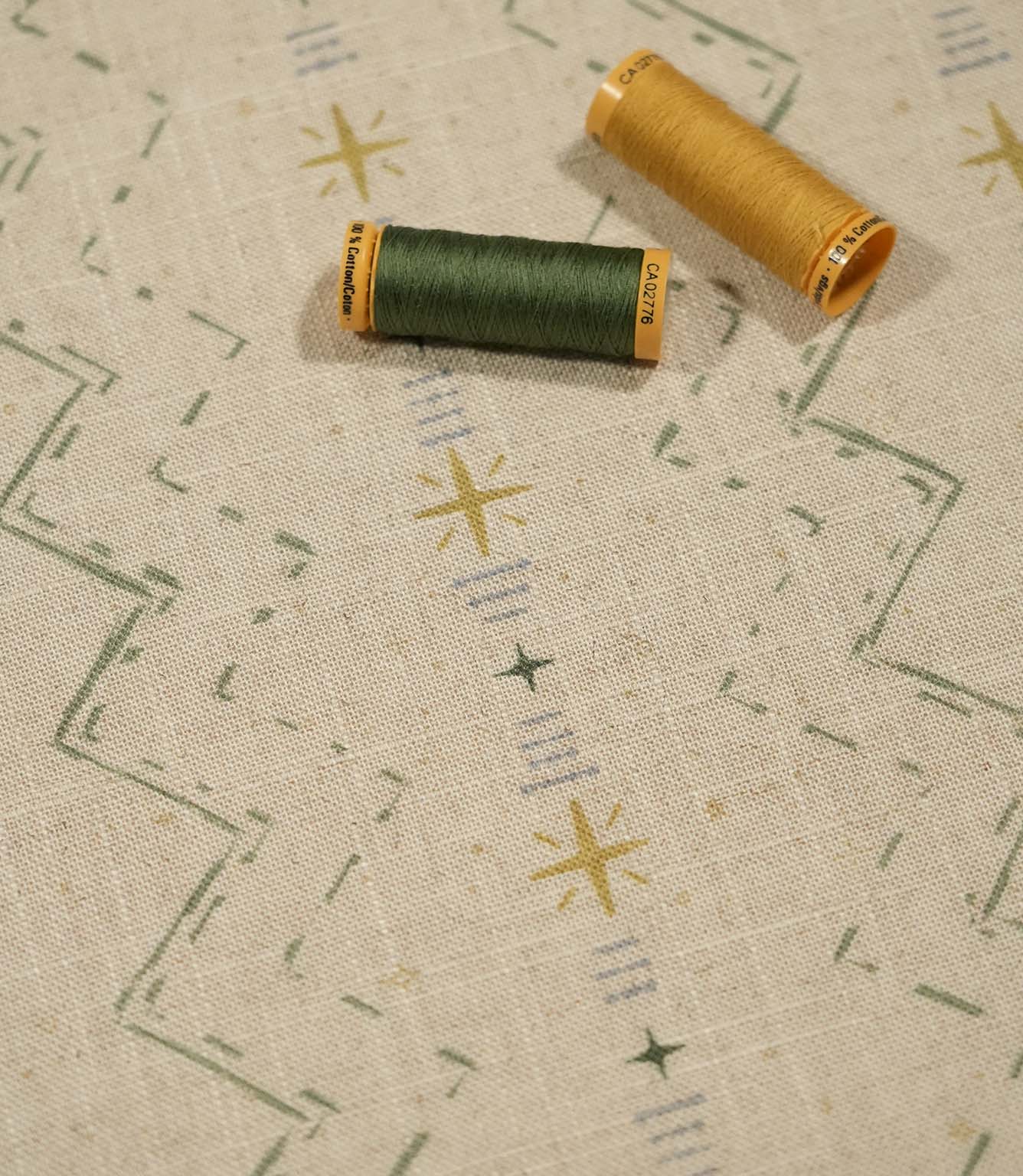 Twilight Mill Green Apple Gold fabric displayed with coordinating green and gold sewing thread, highlighting the contemporary geometric print.