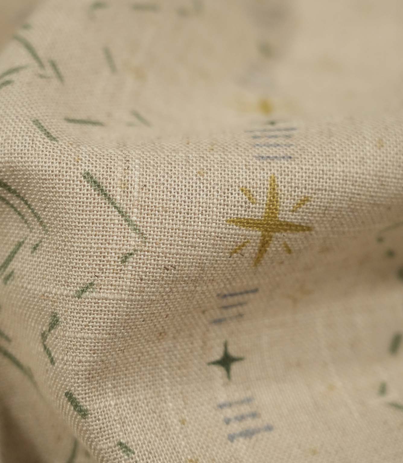 Macro close-up of Twilight Mill Green Apple Gold fabric highlighting the woven texture and hand-drawn geometric design.