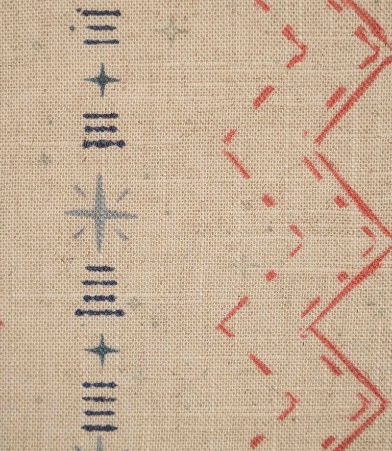 Close-up of Twilight Mill Red Steel Blue fabric showing the hand-drawn geometric motif with red zigzags, steel blue stars and linear accents.
