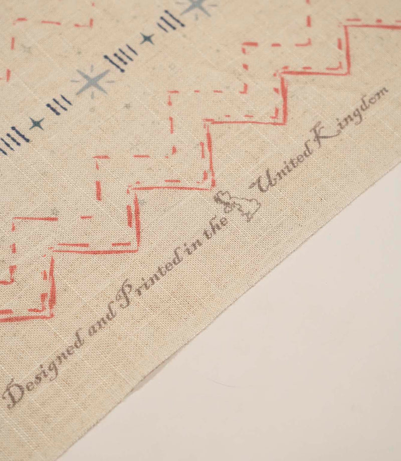 Twilight Mill Red Steel Blue fabric showing the printed geometric design alongside the branded fabric selvedge edge.