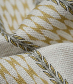 Close-up detail of Varese Gold upholstery fabric showing the woven texture and stylised foliage border.